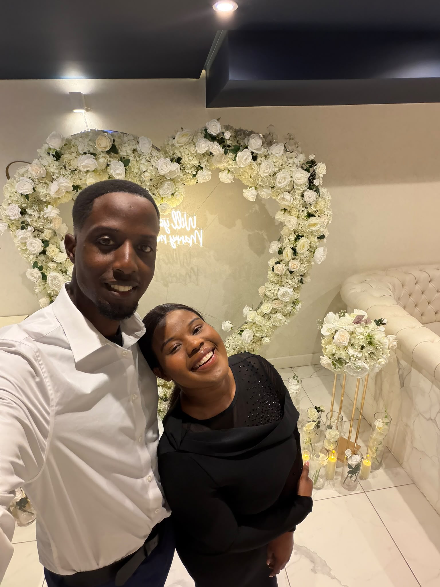 Munashe and Rudo together in front of a flower backdrop